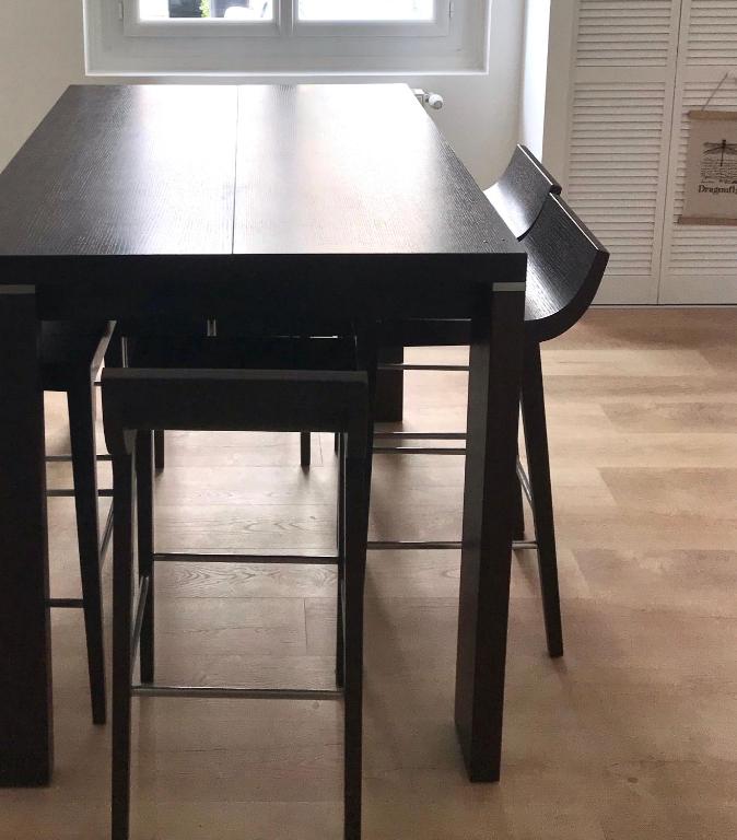 a black dining room table with two black chairs at Maison de vacances in Châtelaillon-Plage