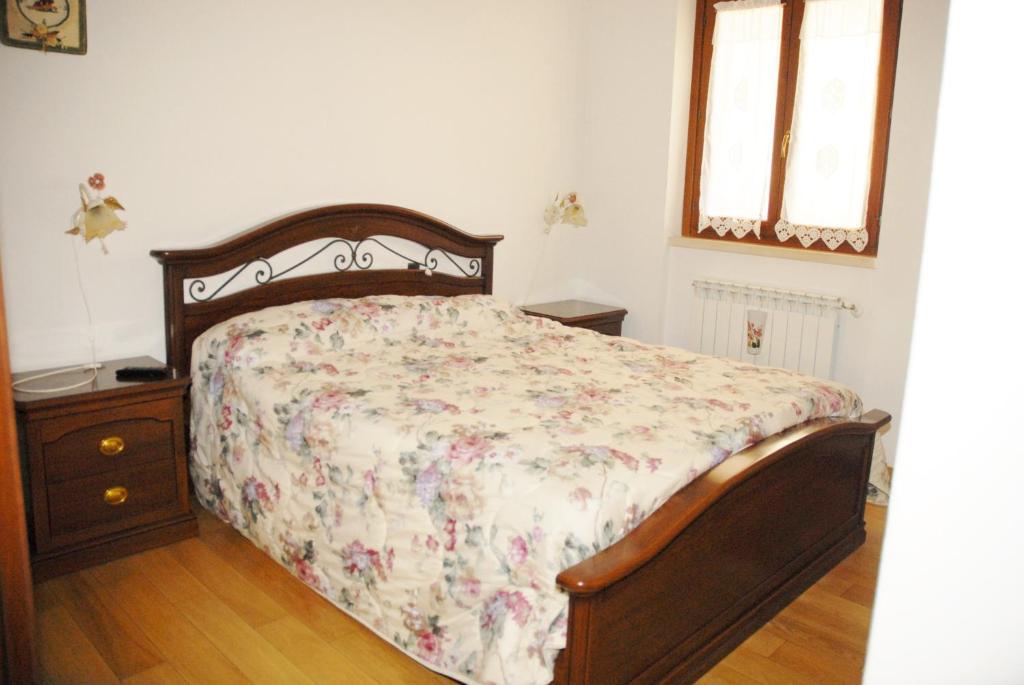 a bedroom with a bed and a dresser and two windows at Casetta a Pescasseroli in Pescasseroli