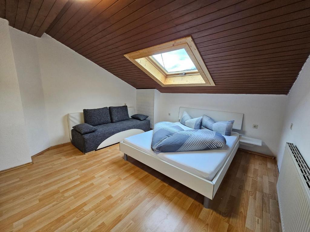 um quarto no sótão com uma cama e um sofá em Haus Lila Stubaital em Fulpmes