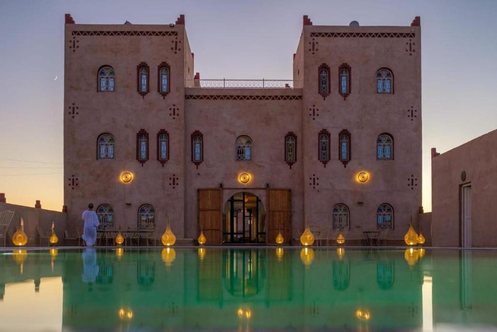 a building with a pool of water in front of it at Dar Morocco in Merzouga