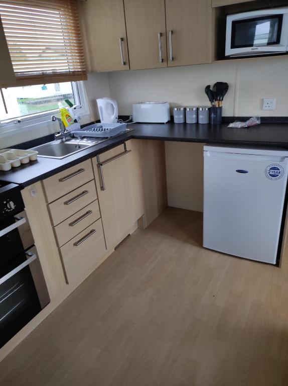 a kitchen with a white refrigerator and a sink at Swift johnson in Parkeston