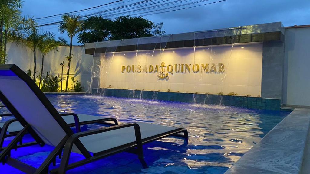 a swimming pool with chairs in front of a building at Pousada Aquino Mar in Paraty