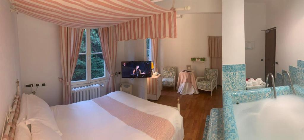 um quarto com uma cama, uma banheira e uma televisão em Eveline 2 - Piscina Privata o Jacuzzi em Sanremo
