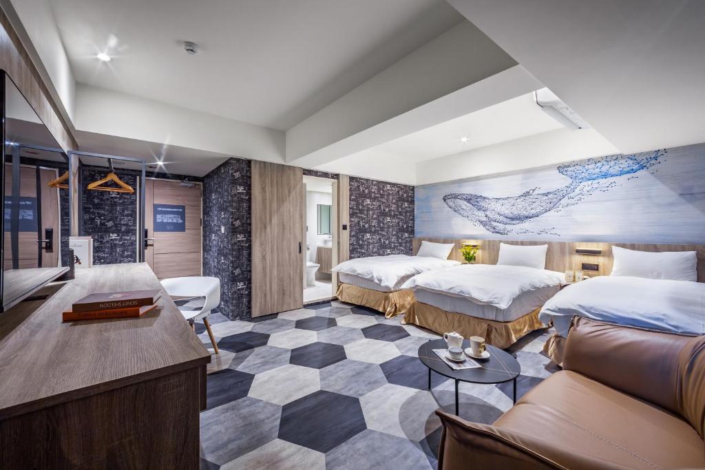 una camera d'albergo con due letti e un divano di 墨鐵會館 a Taichung