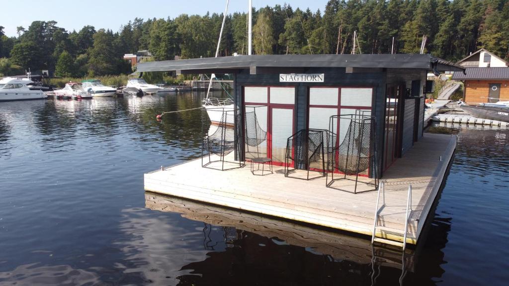 un pequeño muelle con una casa flotante en el agua en StagHorn floating river house, en Jūrmala