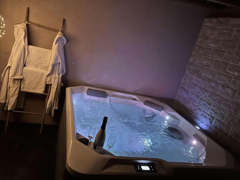 a bath tub with a bottle of wine in it at Doce & Spa proche Colmar in Urschenheim
