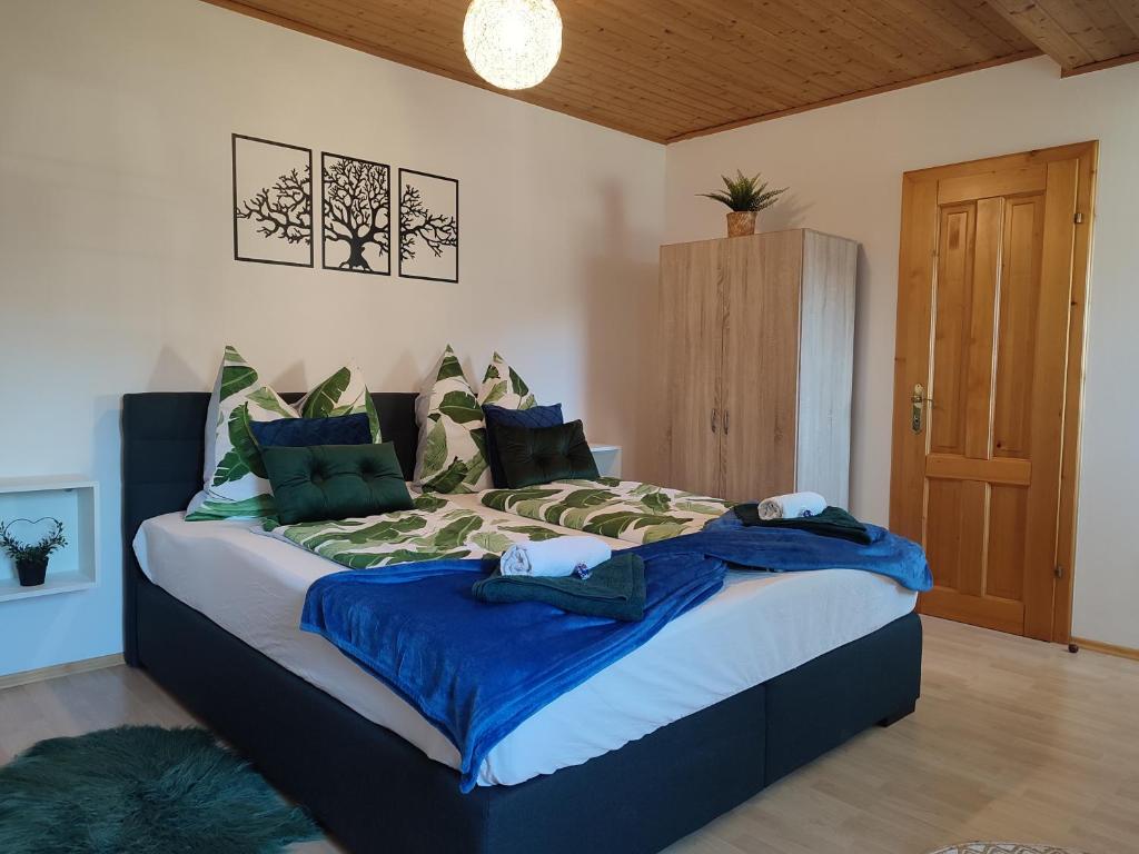 een slaapkamer met een groot bed met blauwe en groene kussens bij Be Home! 2. Apartment Gratkorn in Gratkorn