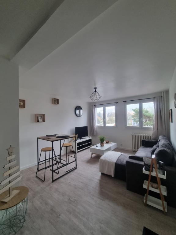 sala de estar con sofá y mesa en Appartement Aurillacois, en Aurillac