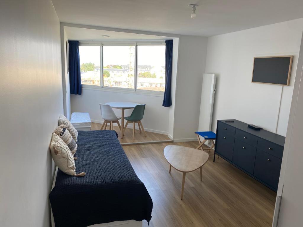una camera con letto e tavolo con sedie di Appartement T2 refait à neuf a Cabourg