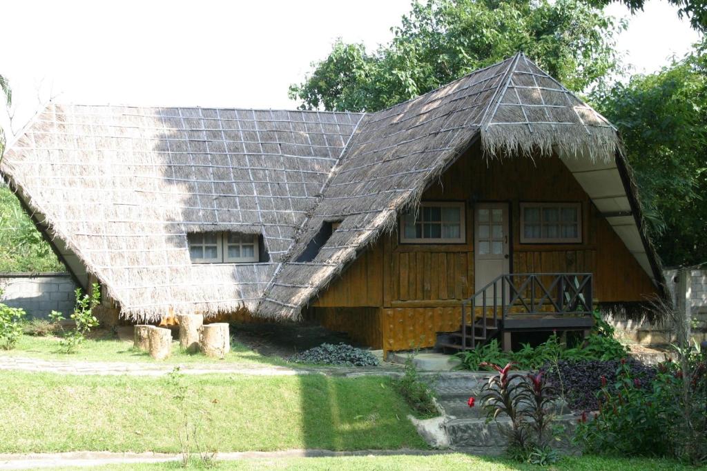 una pequeña casa de madera con techo de paja en Saichonview Riverkwai Resort, en Ban Dan Makham Tia