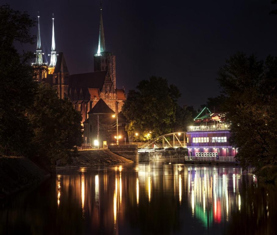 miasto świeci nocą nad rzeką w obiekcie Schronisko na Wyspie we Wrocławiu