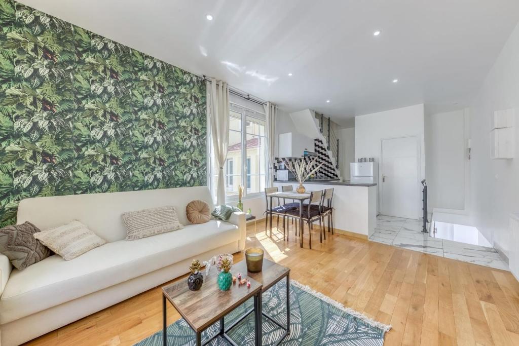 a living room with a couch and a table at Joli Appartement de vacances in Écouen