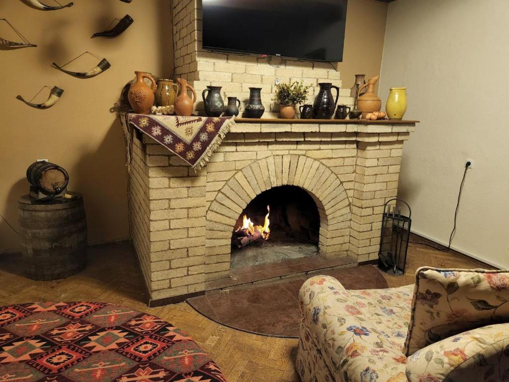 a living room with a brick fireplace with a tv at Guest House Tbilisi style in Tbilisi City