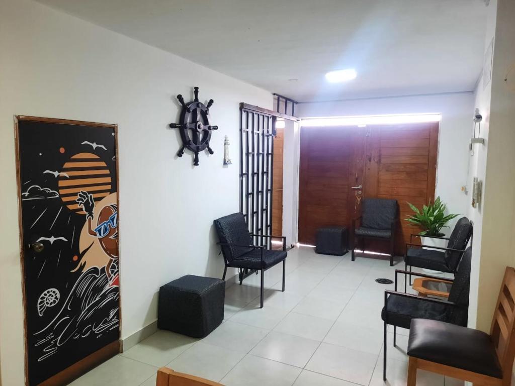 a waiting room with chairs and a door in a building at Hospedaje Kaihalulu in Punta Hermosa