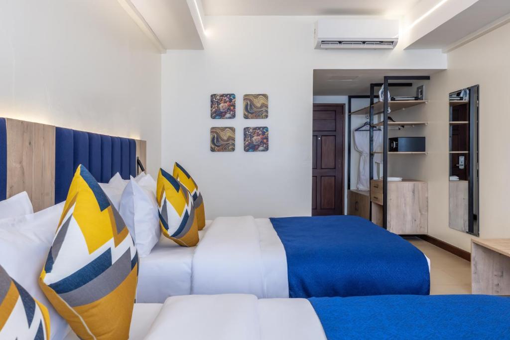 Premium Inn Mombasa City في مومباسا: غرفة فندقية بسريرين ودرج