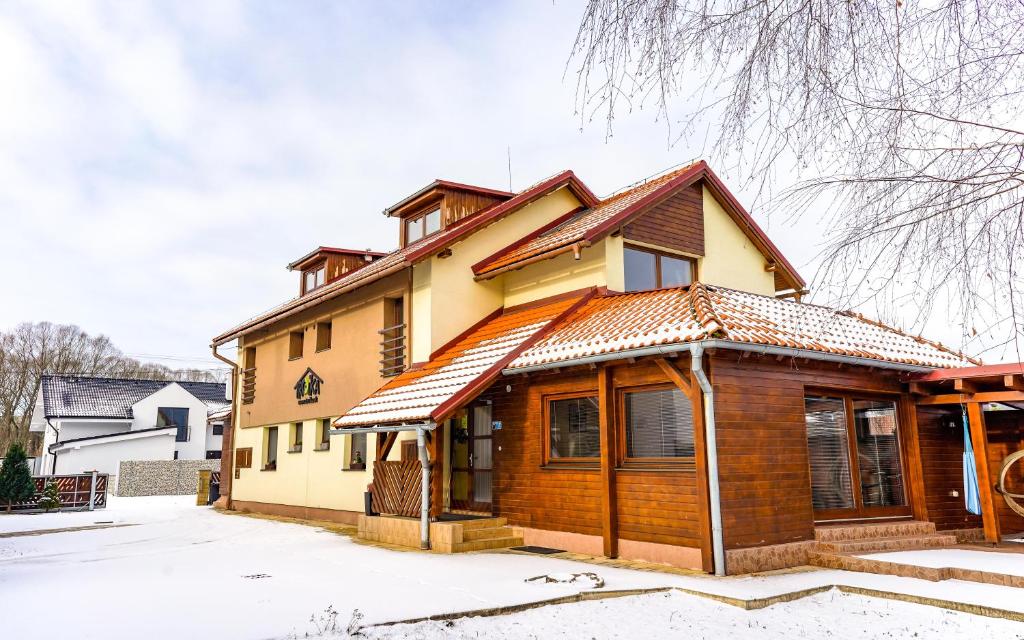 una casa de madera con nieve en el suelo en Studio Troika, en Pavčina Lehota