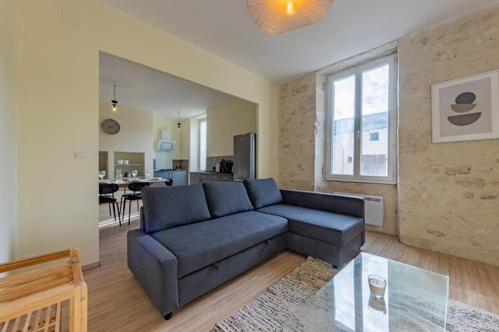 a living room with a couch and a table at Charmant T3 RDC proche commidités parking facile in Montaigu-de-Quercy
