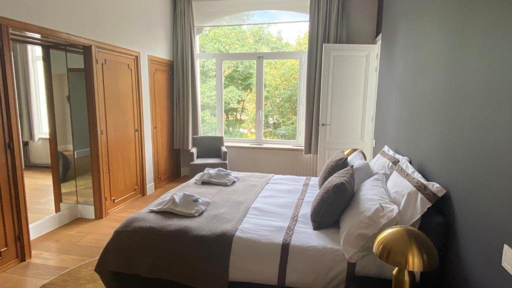 Un dormitorio con una cama y una ventana grande. en SQUARE50 boutique suite, en Ostende