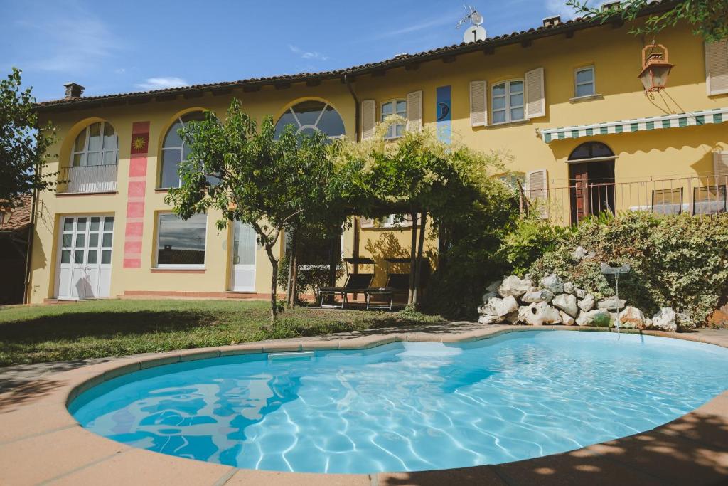 a swimming pool in front of a house at Casa del Sole in Castagnole Lanze