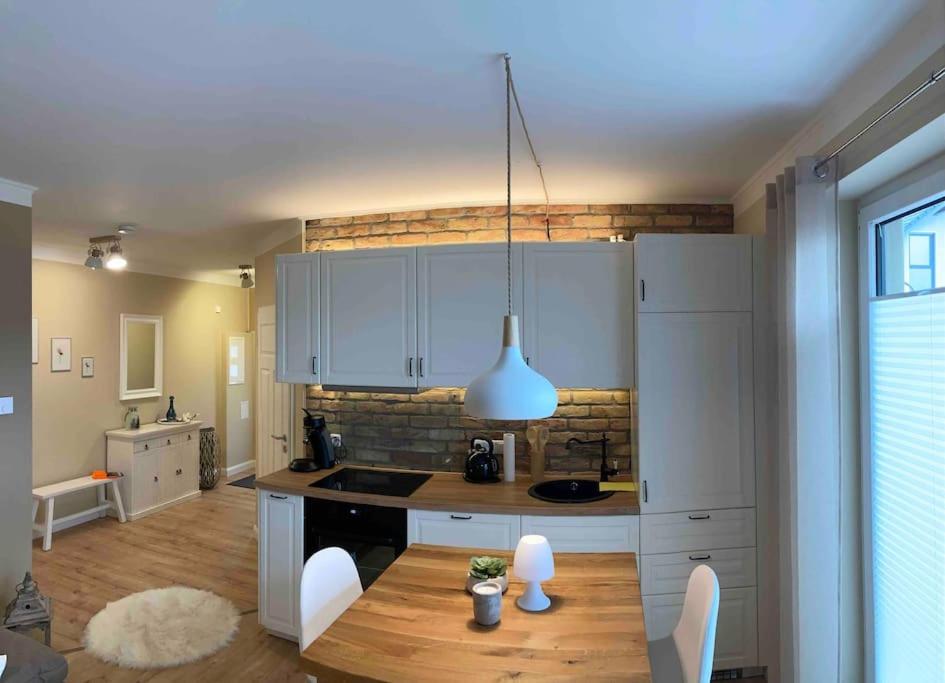 a kitchen with white cabinets and a table with chairs at Ferienwohnung ,,Hermine“ Zur Alten Mühle in Linthe
