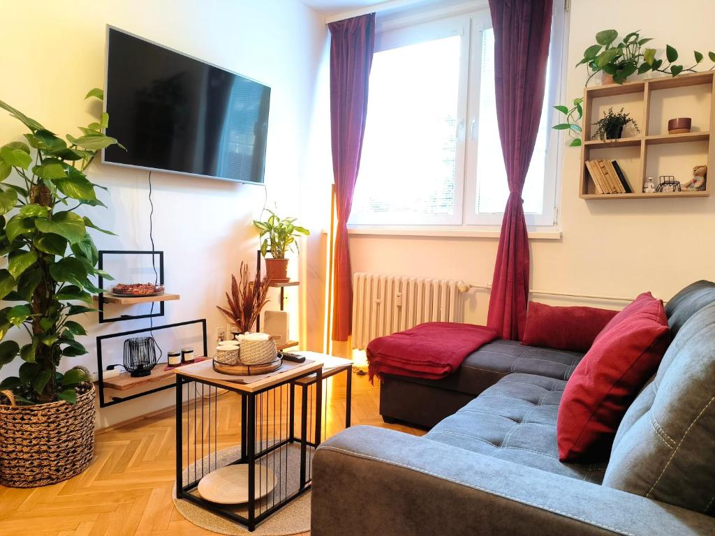ein Wohnzimmer mit einem Sofa und einem TV in der Unterkunft CozyHome Medena Central, quiet premium spot in Old Town in Bratislava