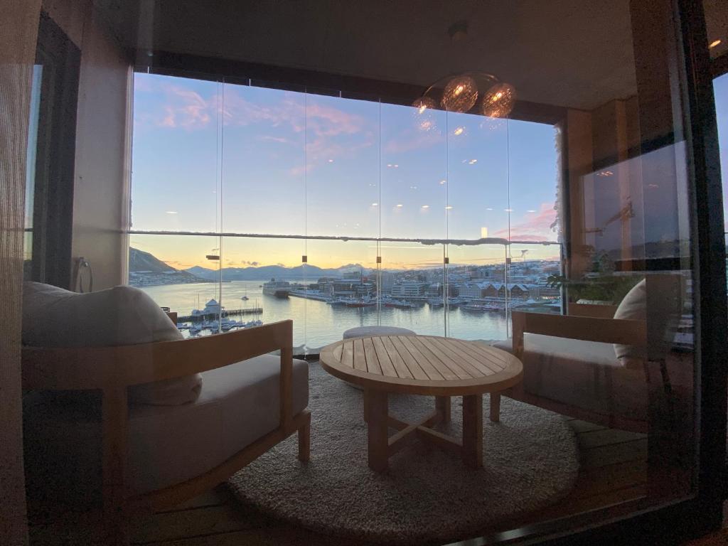 a room with a large window with a view of a harbor at Vindlys Luxury Penthouse Apartment in Tromsø