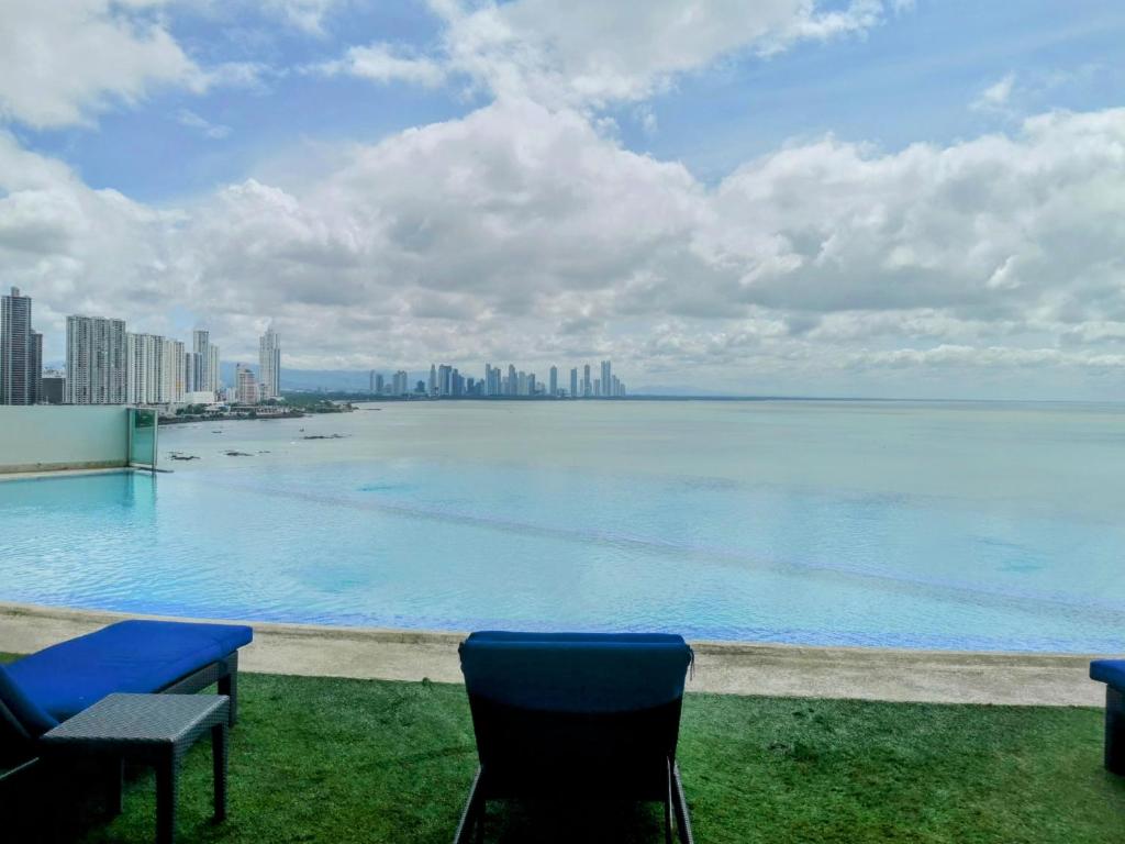 a pool with chairs and a view of the city at Punta Pacífica Oceanfront apartment in Panama City