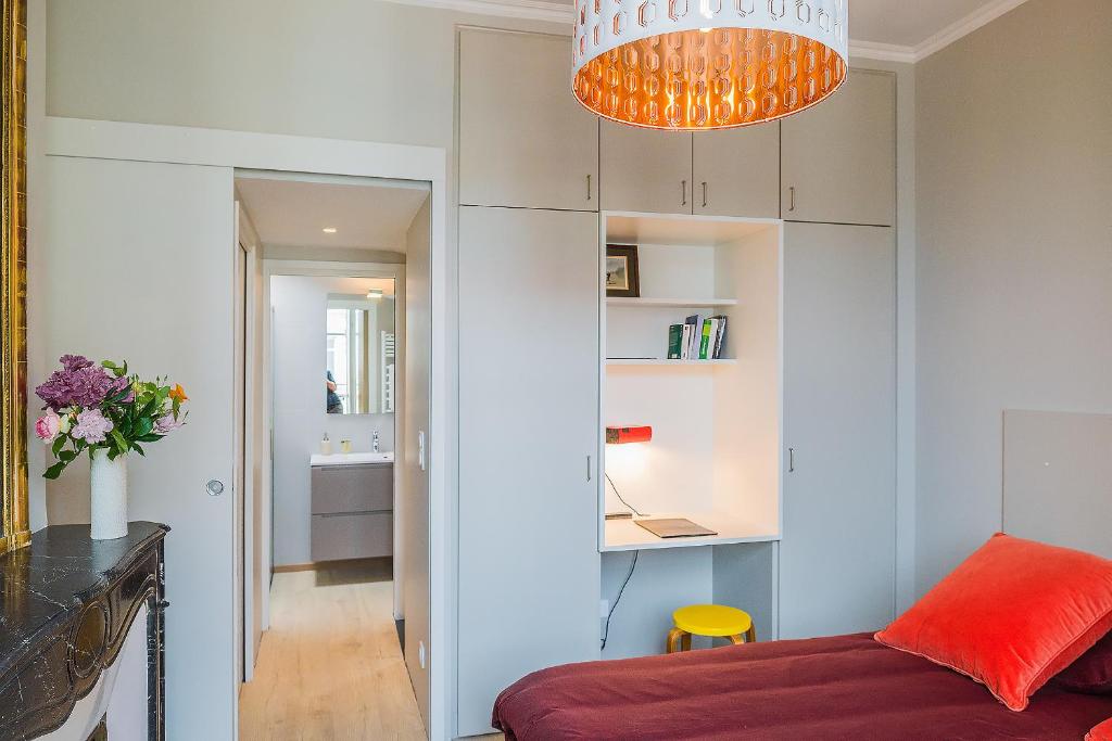 a living room with a red couch and a chandelier at Appartement 11 place d'Alliance in Nancy