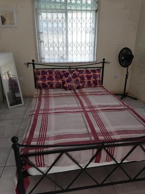 1 cama grande en un dormitorio con ventana en L & J Apartments en Dawhwenya