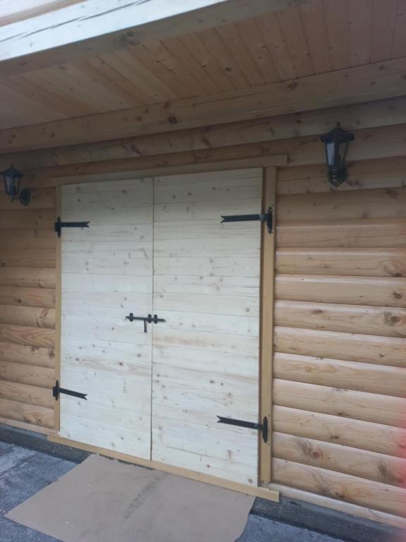 a large wooden garage with two doors at Nice cabin in Cetinje