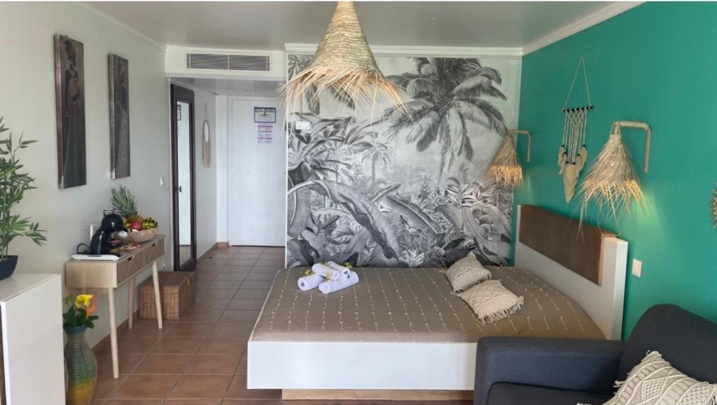 uma sala de estar com um sofá e um mural em Couleur Caraïbes 2 Appartements Communicants Vue Mer Pierre&Vacances em Sainte-Luce