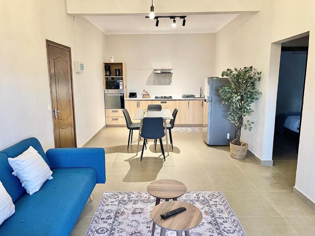 a living room with a blue couch and a table at Pebble Bay Garden View F3 in Grand Baie