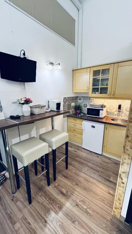 a kitchen with a table and two chairs and a counter at Mirage Apartments Váci Street in Budapest