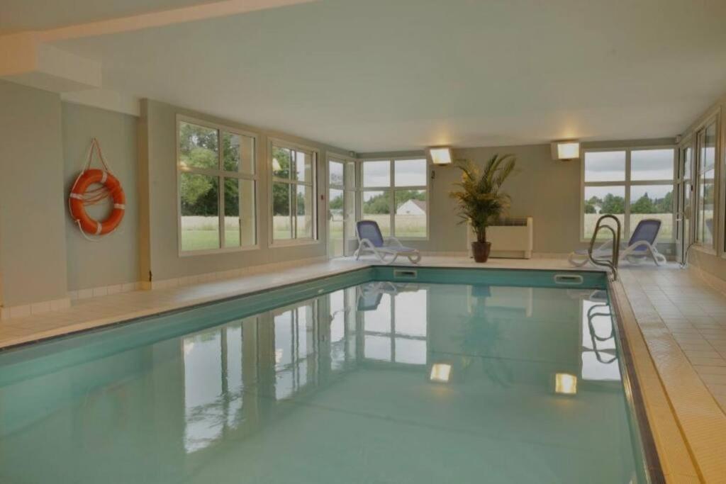 - une piscine dans une maison dotée de fenêtres dans l'établissement Chez Jack-Résidence-Piscine-Sauna, à Levernois
