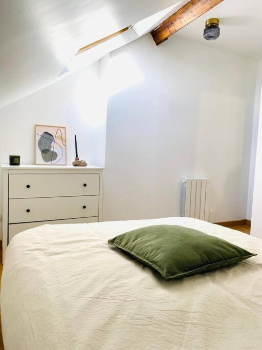 a bedroom with a bed with a pillow and a dresser at Appartement Duplex Cosy in Le Havre