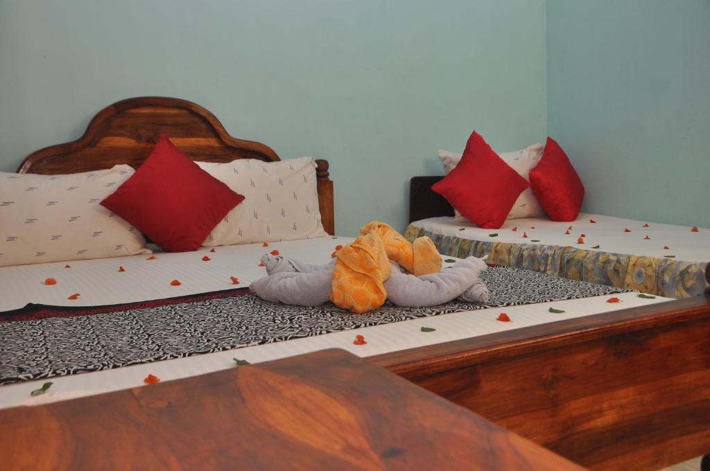two beds in a room with stuffed animals on them at Purasanda Villa in Sigiriya