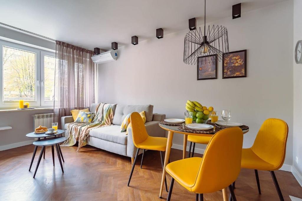 ワルシャワにあるRent like home - Bruna 2のリビングルーム(ソファ、テーブル、黄色い椅子付)