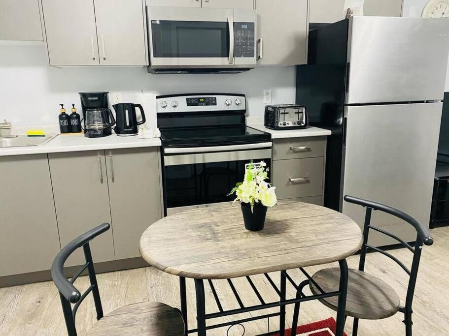 a small kitchen with a table with flowers on it at Olive Place in Saskatoon