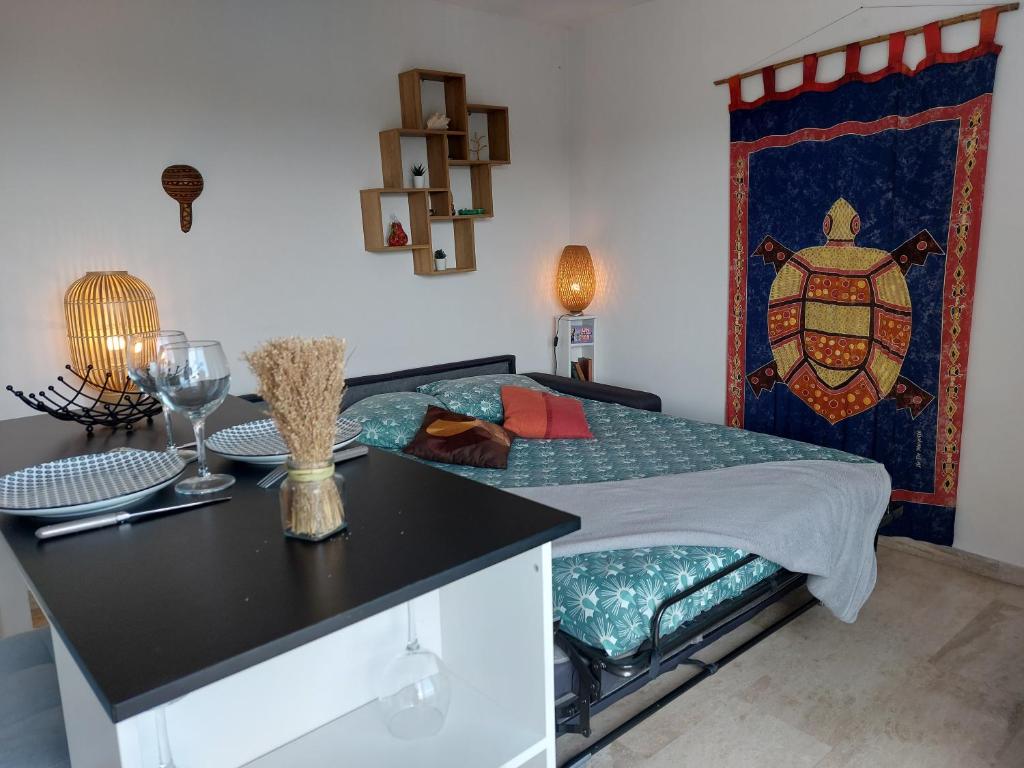 a bedroom with a bed with a table and a counter at Studio Golf Riviera - Axelle Loc'Appart in Mandelieu-La Napoule