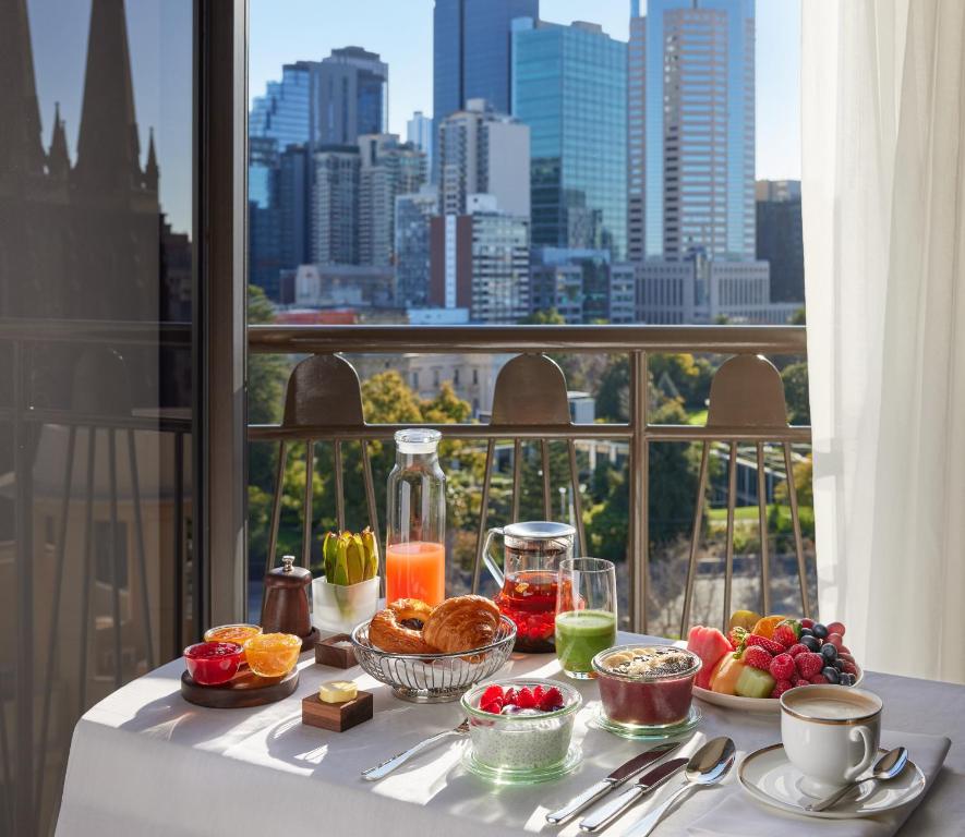 a table with food on it with a view of a city at Park Hyatt Melbourne in Melbourne