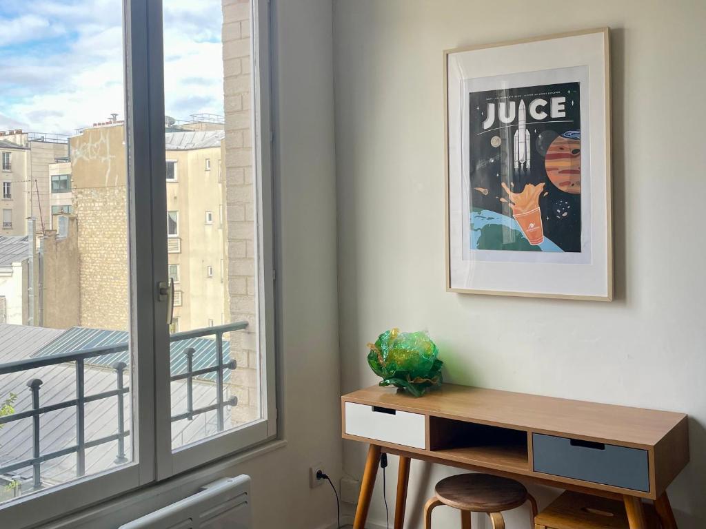 Cette chambre dispose d'un bureau à côté d'une fenêtre. dans l'établissement Jupiter 101 Studio Montmartre, à Paris