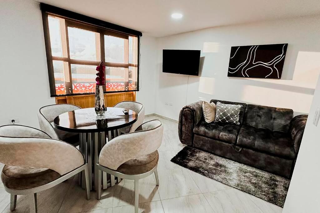 sala de estar con mesa y sofá en Apartamento 307 - Vista a la Represa - 1 Habitación y Sofa Cama - Rentas Cortas Gerencial, en Guatapé