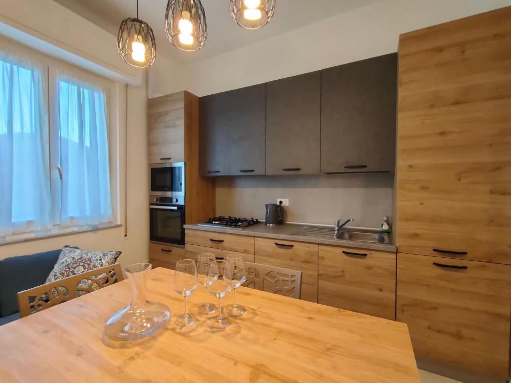 a kitchen with a wooden table with wine glasses on it at Casa Ewa - Centro Pesaro in Pesaro