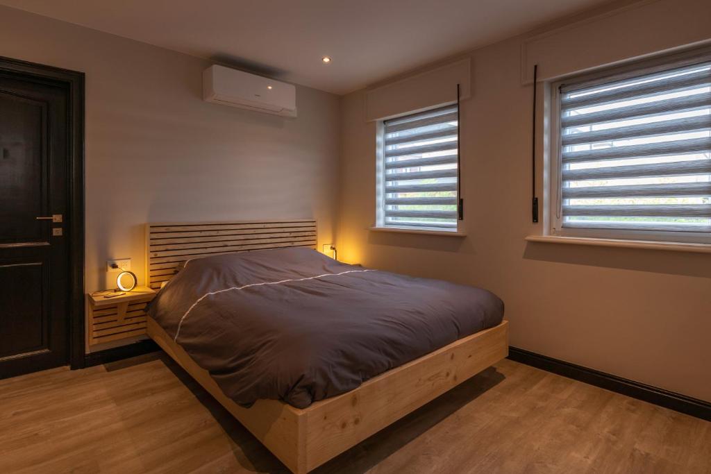 a bedroom with a bed and two windows at Mille'n'8 in Riemst