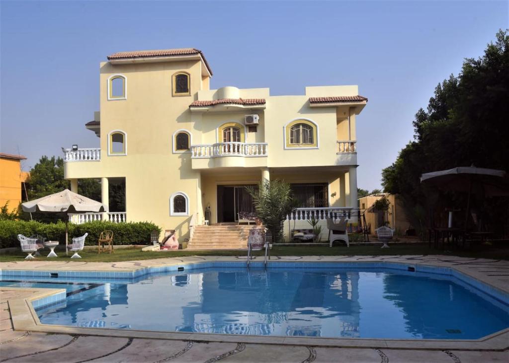 a villa with a swimming pool in front of a house at الريف الاوروبي in Al Qaţā