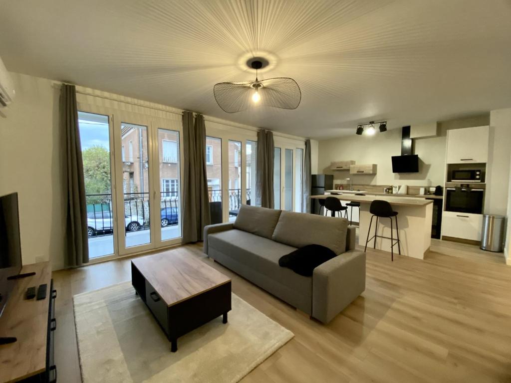 uma sala de estar com um sofá e uma mesa em Appartement neuf et spacieux, centre ville, garage em Tournon-sur-Rhône