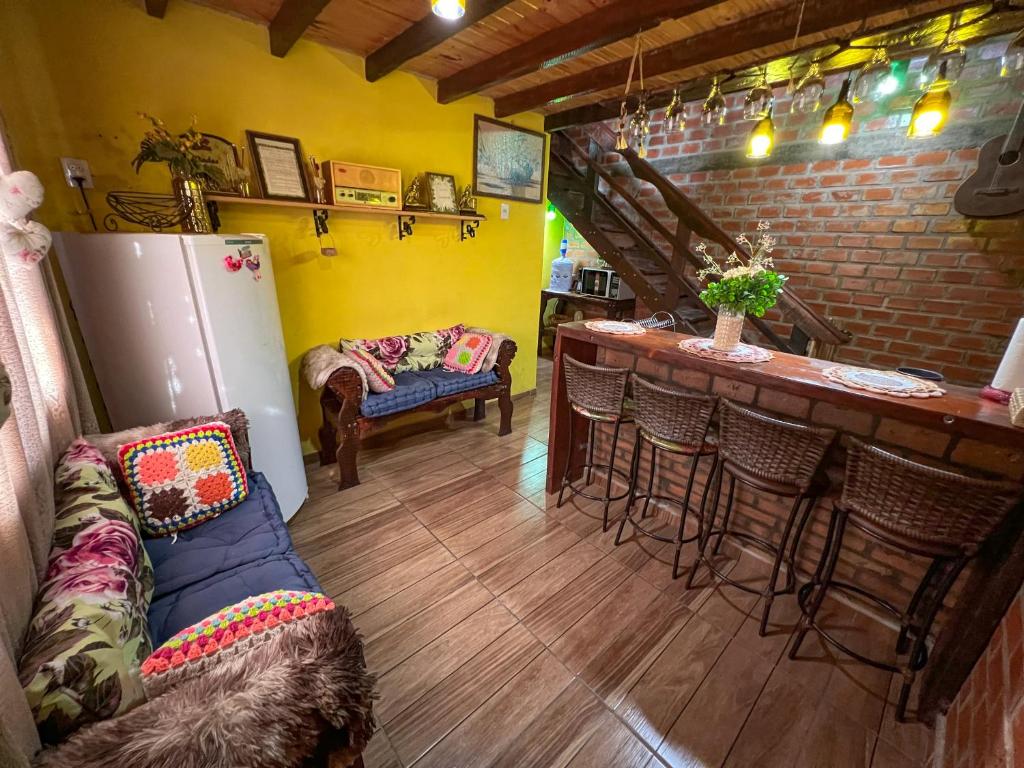 uma sala de estar com um bar e um sofá em Pousada Tarumã challes 01 em Bonito