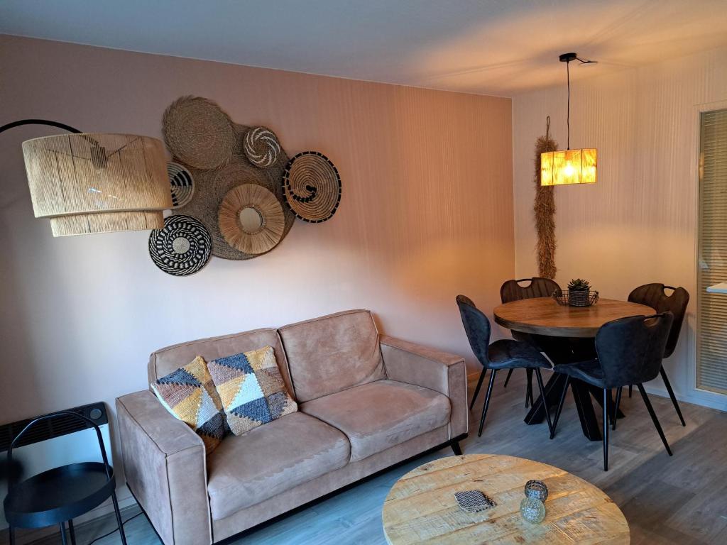 een woonkamer met een bank en een tafel bij 't Klèène Genot in Hollum
