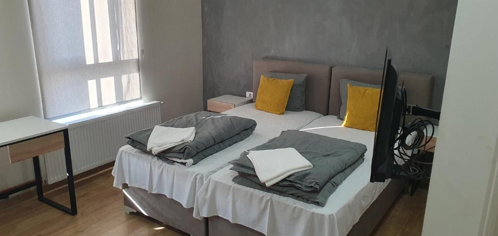 um quarto com uma cama com duas almofadas em Apartmani Stara Skola 