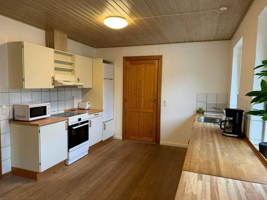 a kitchen with white appliances and a wooden floor at House in Billund in Billund